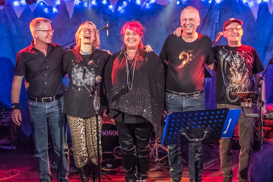 Band posiert gemeinsam auf der Bühne – Bandcoaching in der Praxis